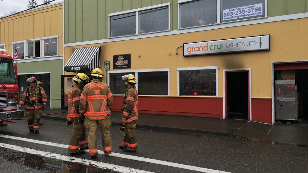 Firefighters standing outside restaurant with sign