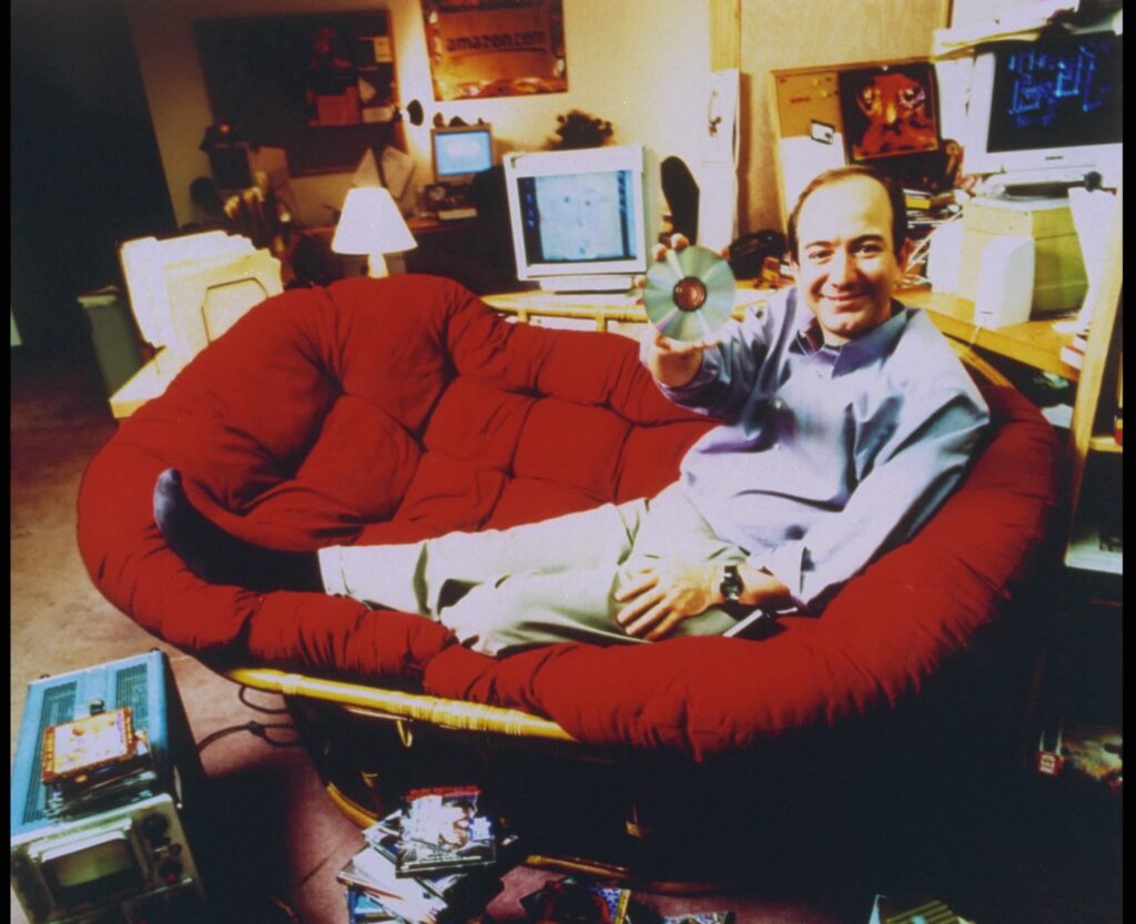Person on red papasan chair holding CD
