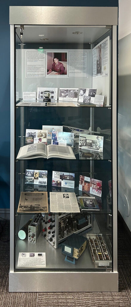 Museum display case with historical documents and photos